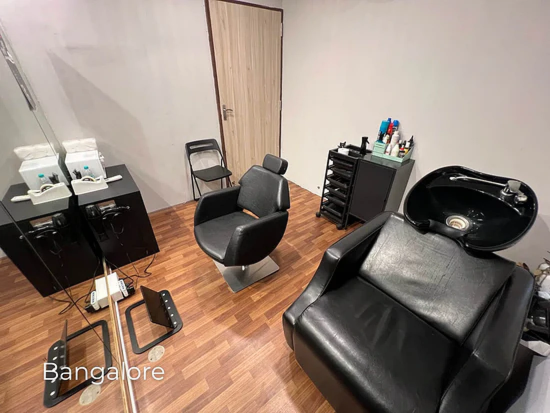 The Topee waiting lounge at the Old Airport Road studio, with seating and hair-system display