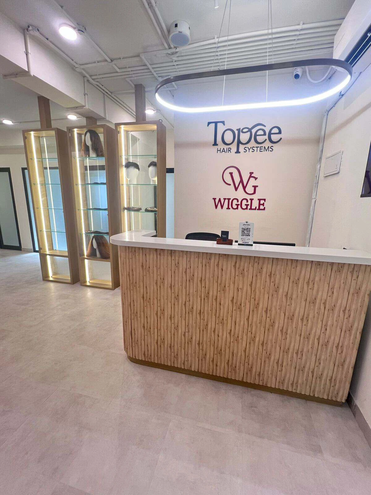 The Topee reception and lit hair-system display cabinets at the Old Airport Road studio, Bengaluru